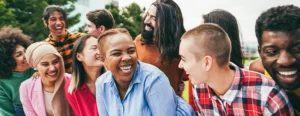 group of smiling diverse people in bright clothing looking around at each other